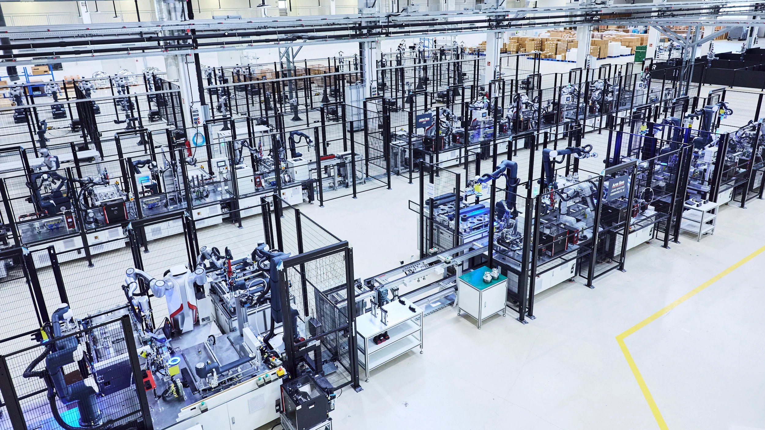 Aerial view of Agile Robots production cells with fenced robot arms and mobile platforms