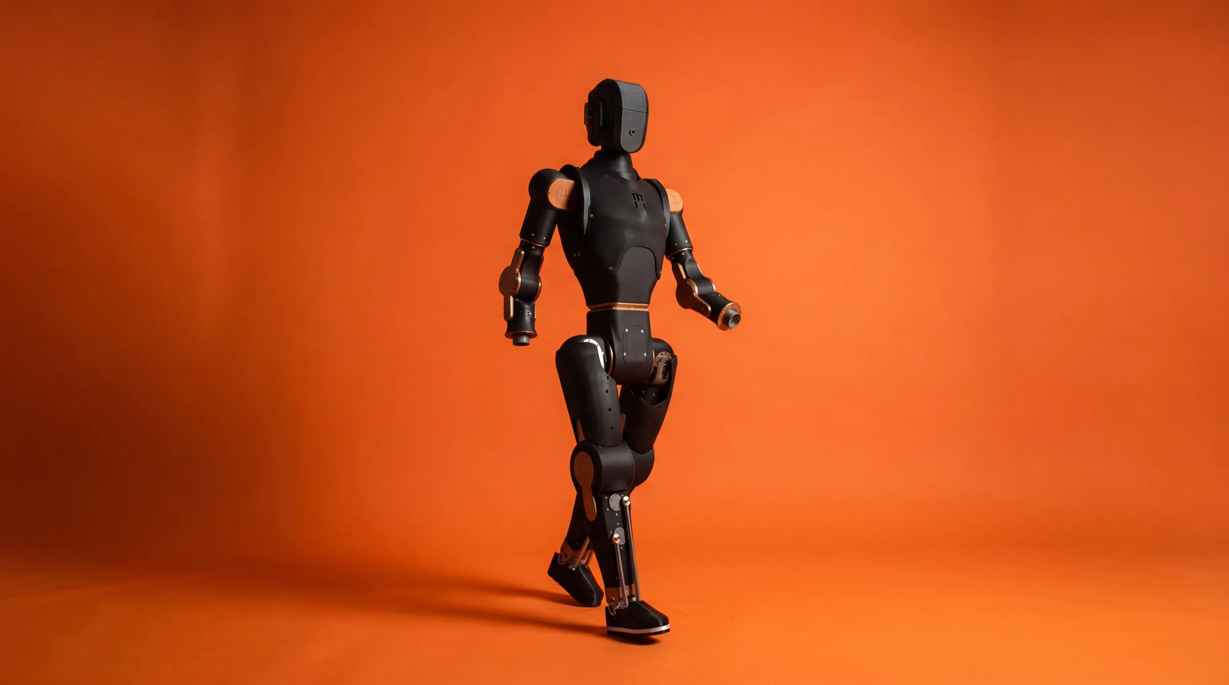 Full-body Asimov humanoid in walking pose on orange backdrop