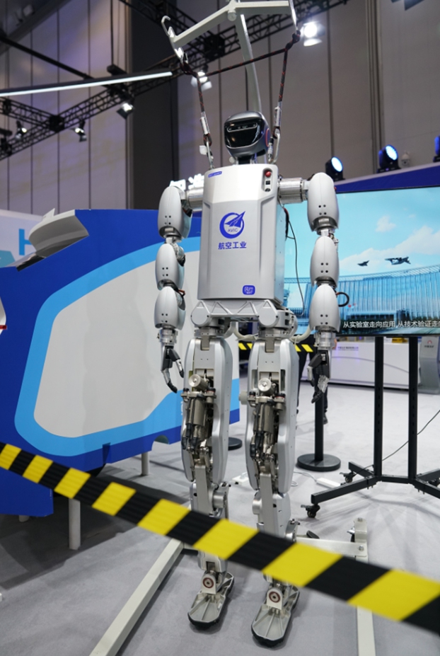 AVIC Fengxing-001 humanoid standing on a WRC booth platform with an overhead support rig