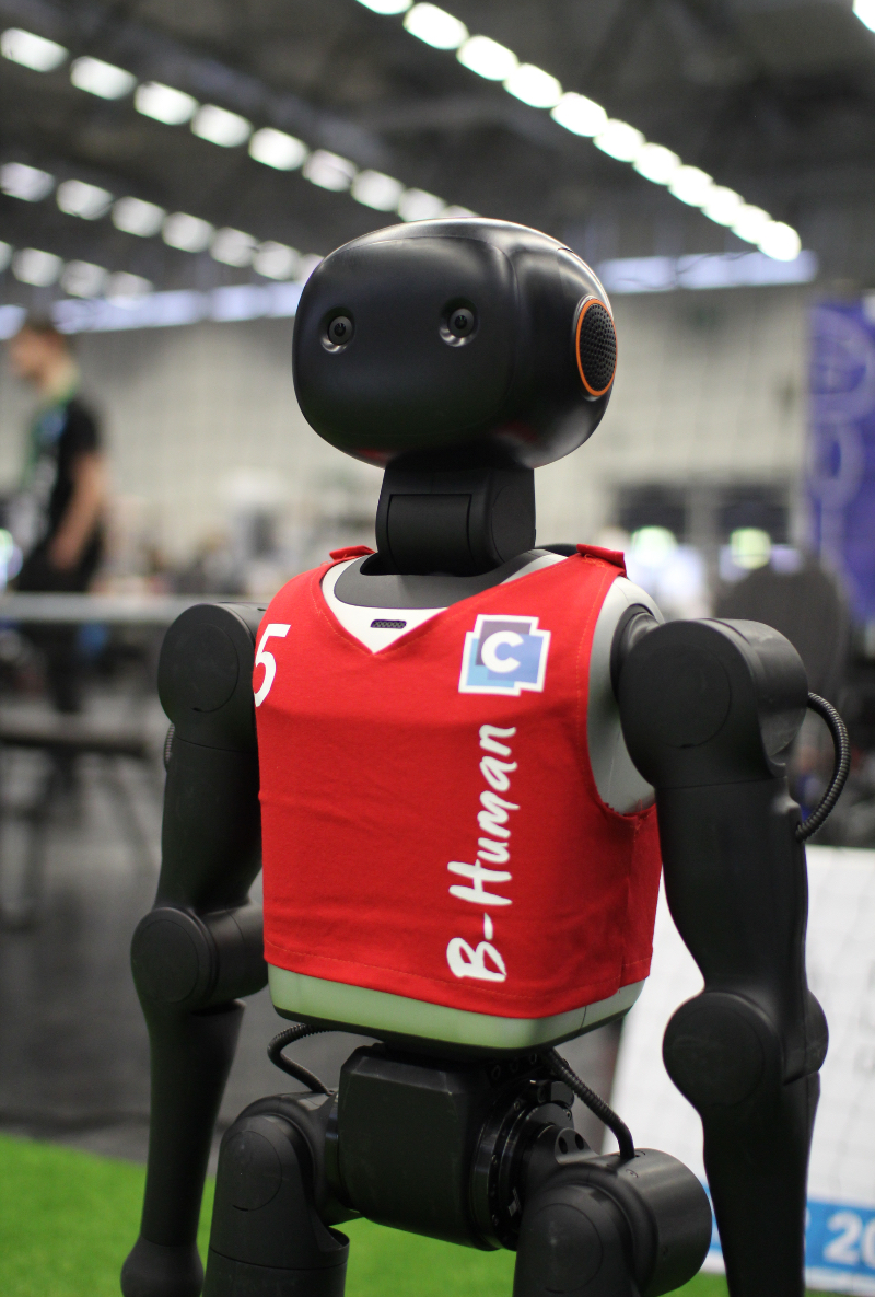 Close-up of a B-Human robot in a red CONTACT Software jersey numbered 5