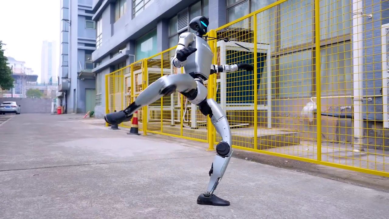 Unitree G1 humanoid kicking on an outdoor paved path beside a yellow fence