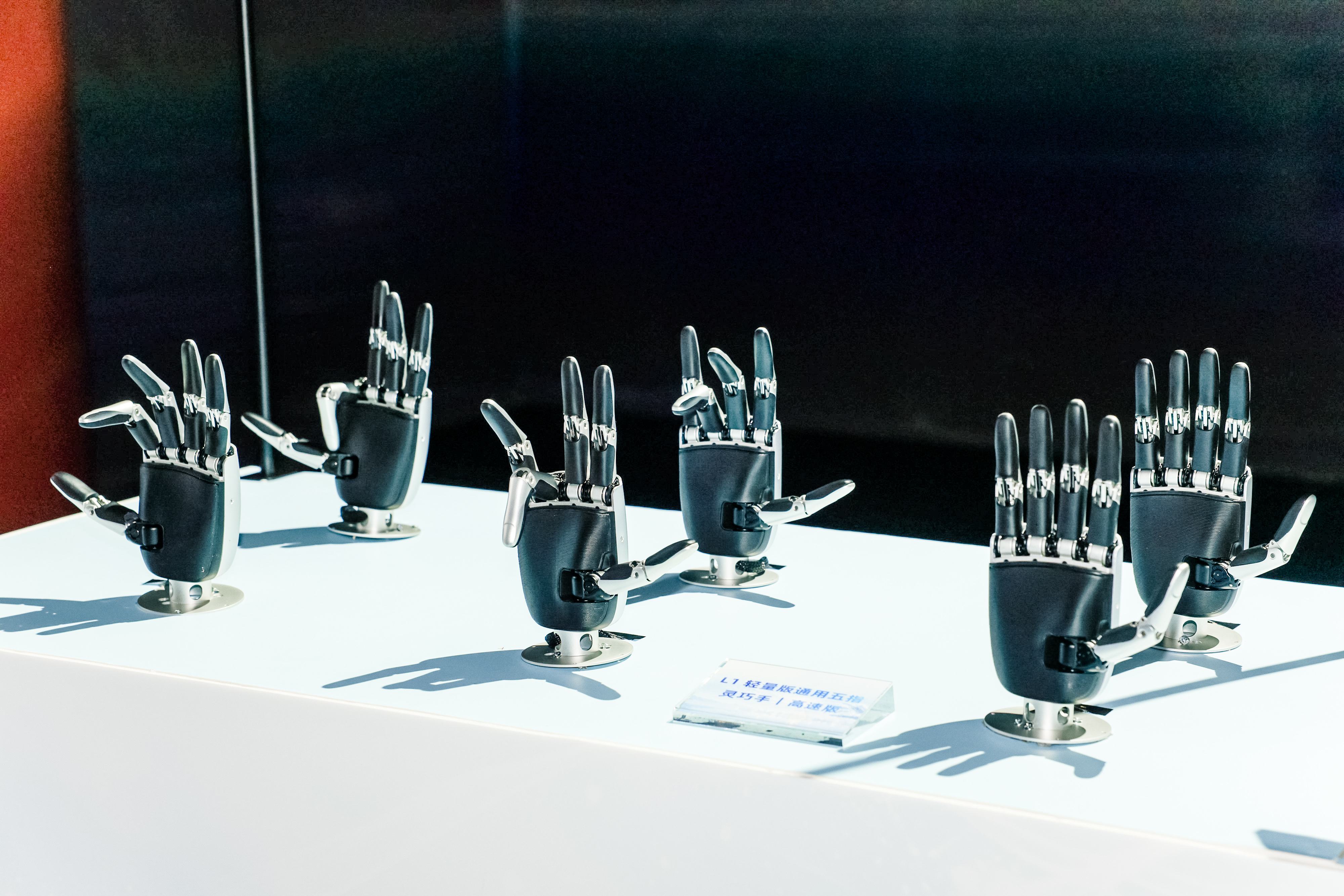 Six CASBOT L1 five-finger hands posed on a white display table