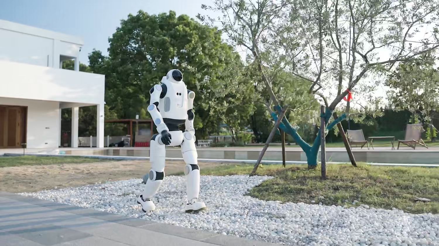 White DOBOT LUMO humanoid standing on gravel outdoors near a modern house