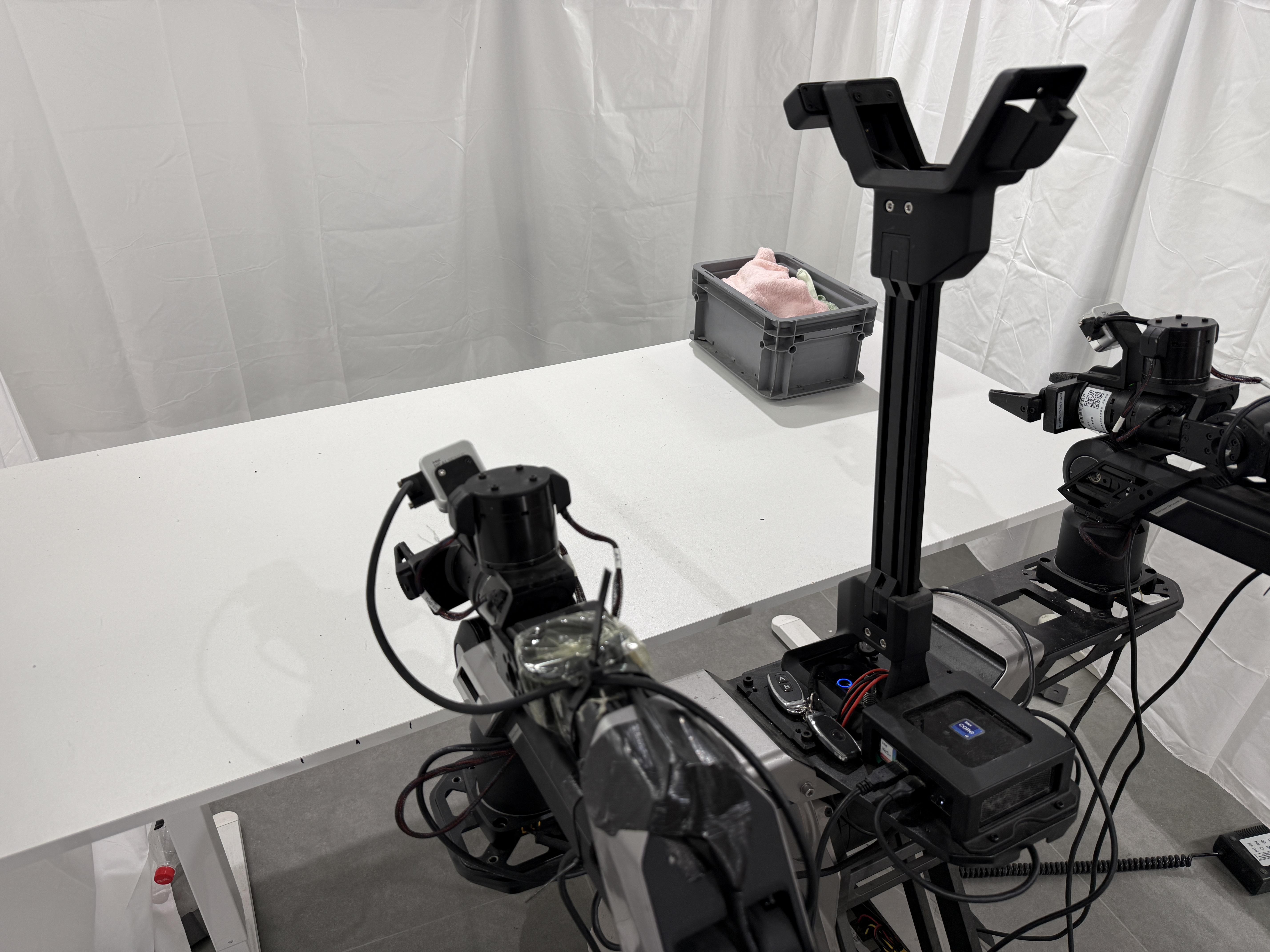 Galaxea R1-Lite dual-arm robot at a white table with a crate of towels