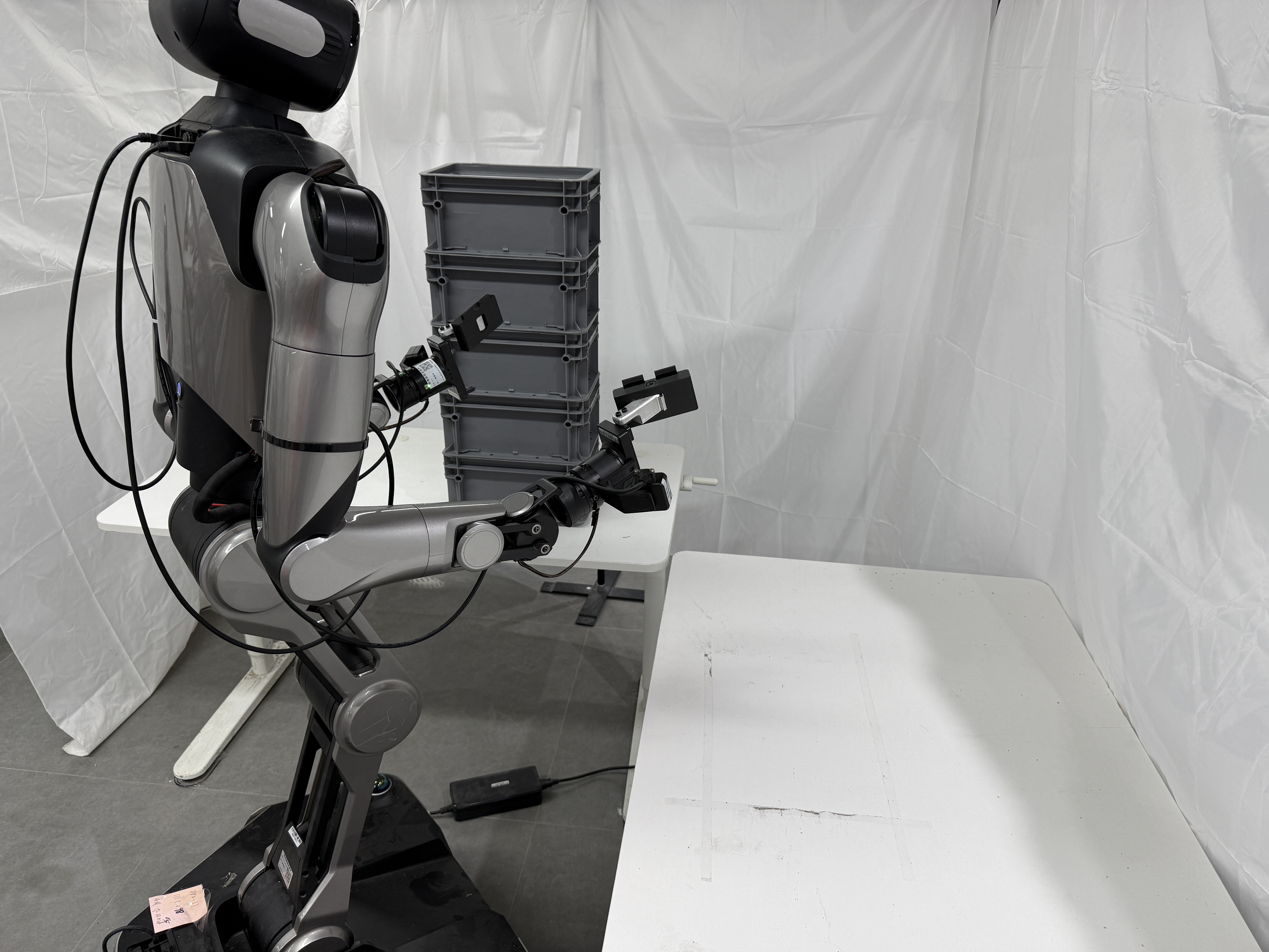 Galaxea R1-Pro humanoid upper body stacking gray crates on a table