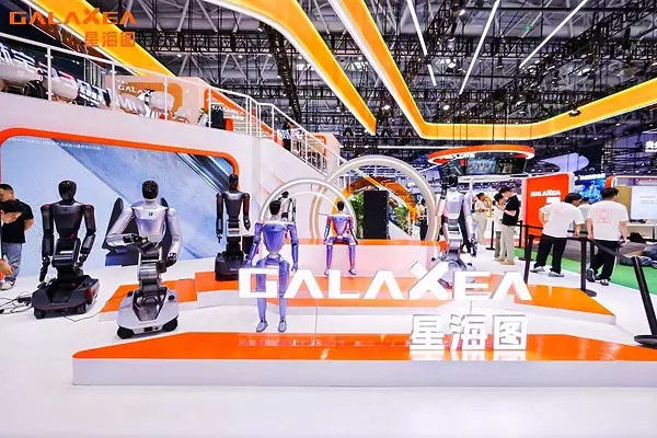 Galaxea WRC booth with wheeled and bipedal robots around an orange GALAXEA sign