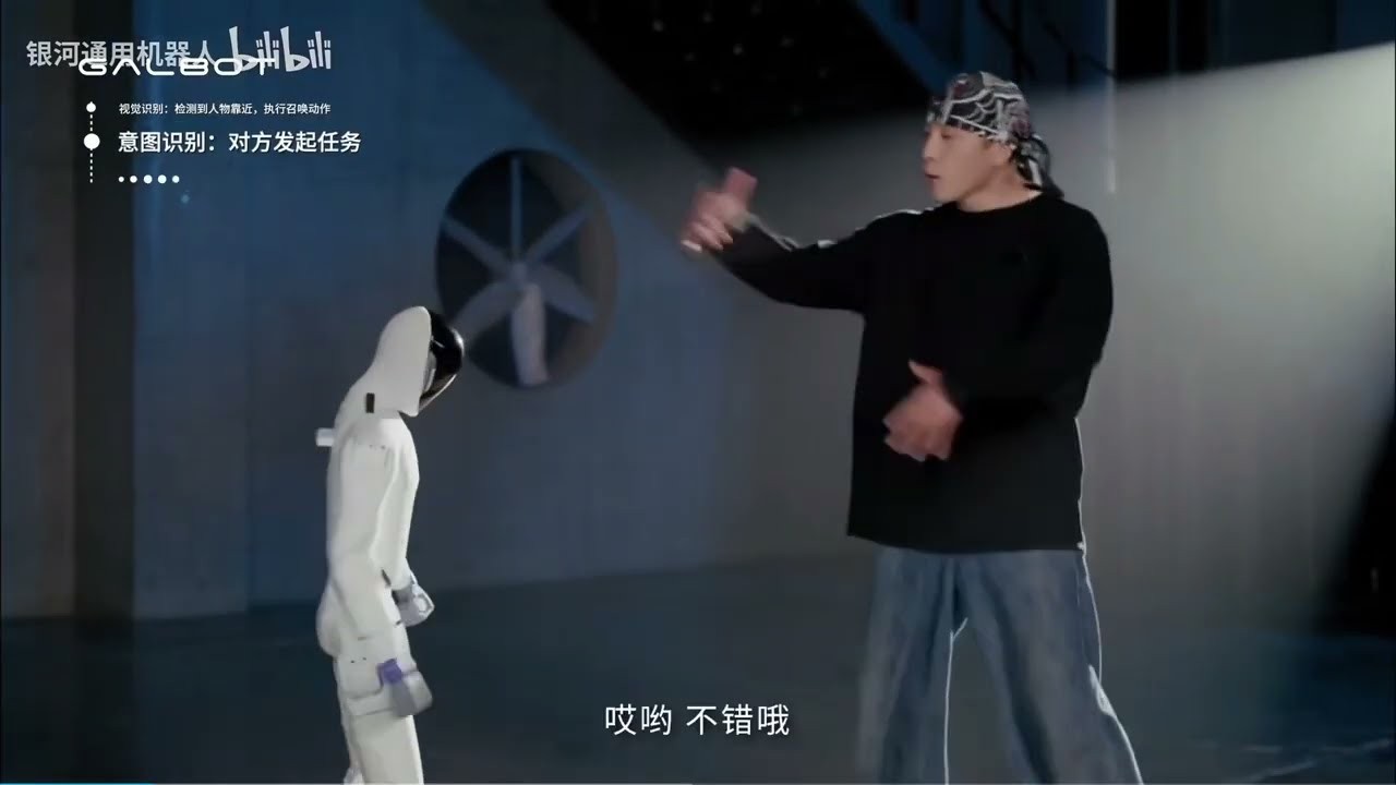 Galbot wheeled humanoid interacting with a person on a studio floor