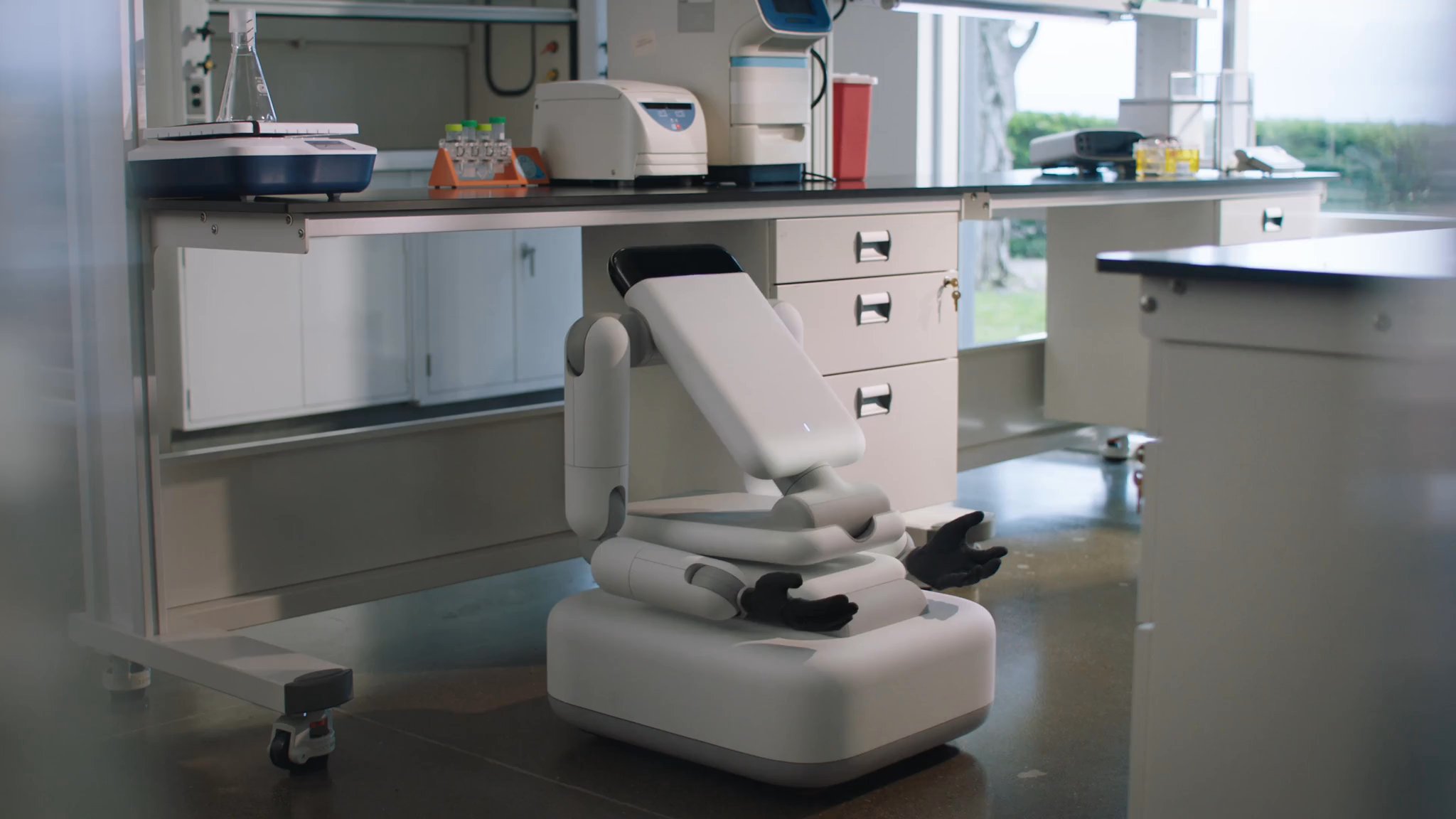 Genesis AI Eno folded compact on wheels in a laboratory