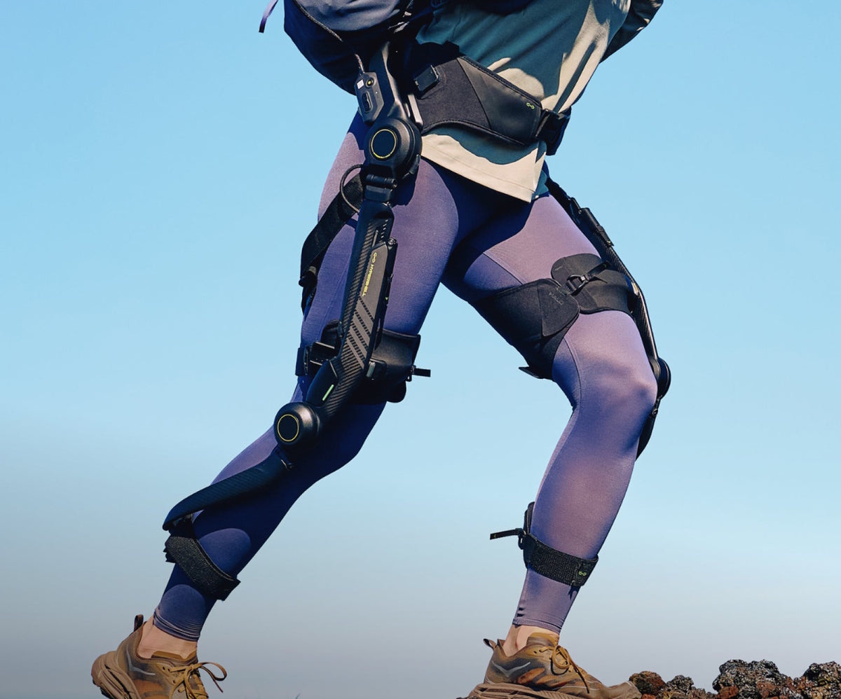 Hiker wearing the Hypershell Halo full-leg exoskeleton, hip and knee motors visible