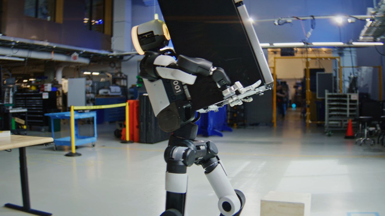 Boston Dynamics Atlas humanoid lifting a large appliance in a lab