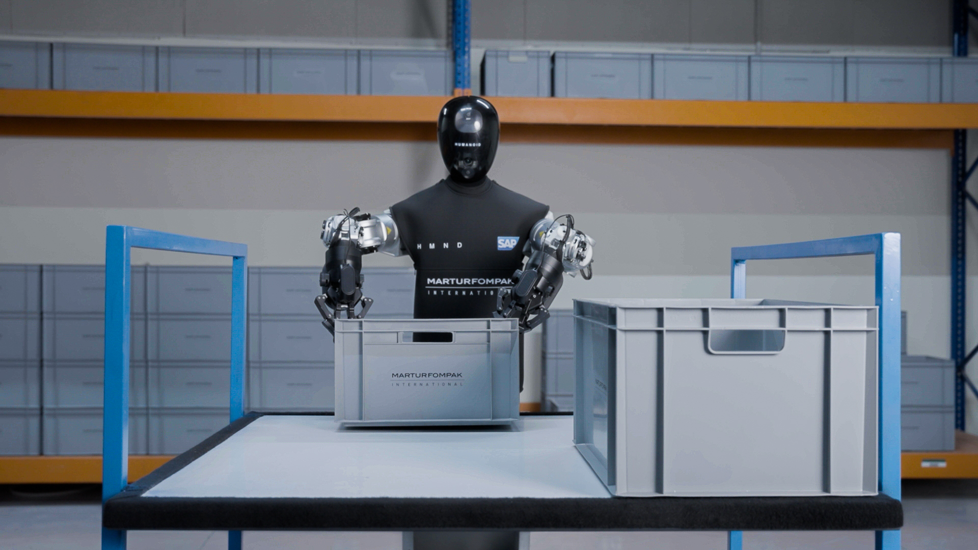 Humanoid Alpha robot handling a tote on a warehouse table