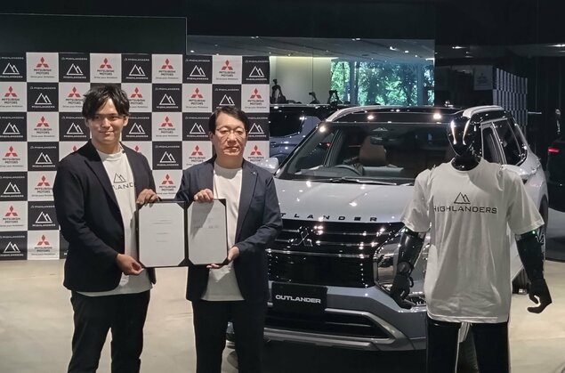 Mitsubishi Motors CEO Takao Kato and Highlanders CEO Hiroya Masuoka with a humanoid robot