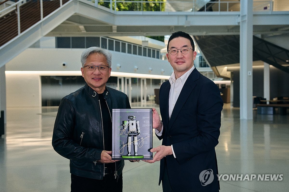 Huang and Koo hold a boxed miniature humanoid after signing the MOU
