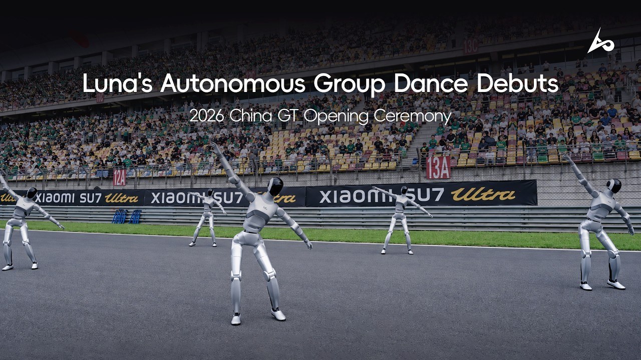 Five silver Luna humanoids dancing on a racetrack in front of packed grandstands