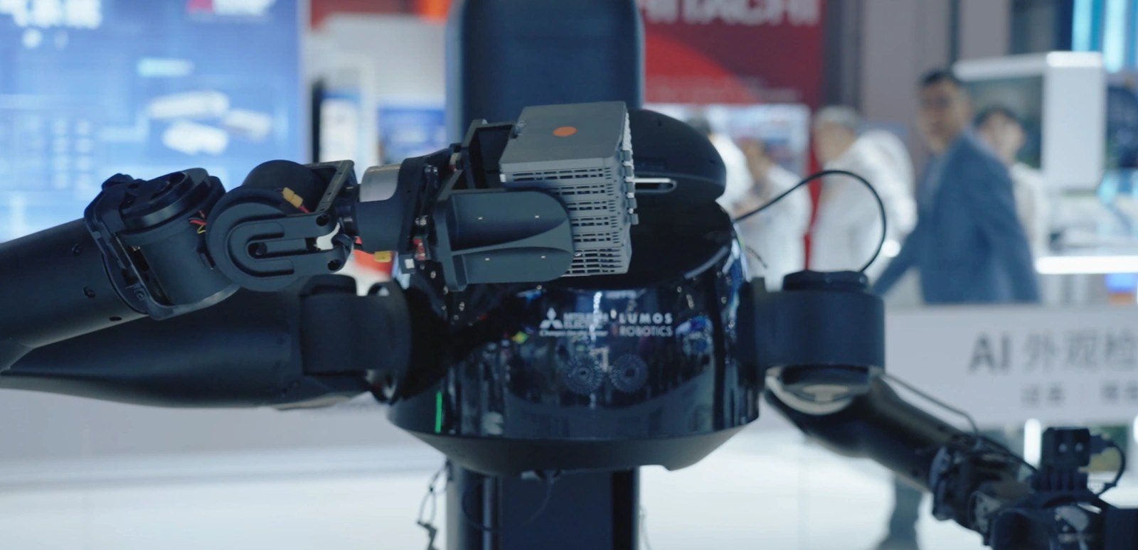 Lumos arm holding a PLC module, Mitsubishi and Lumos logos on the torso