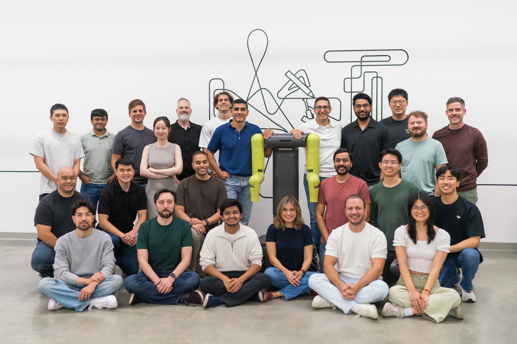Maven team standing around a wheeled dual-arm robot with lime-green arms