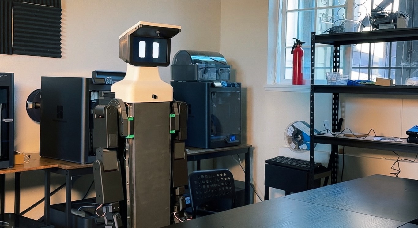 Nori dual-arm wheeled robot standing in a San Francisco workshop among 3D printers