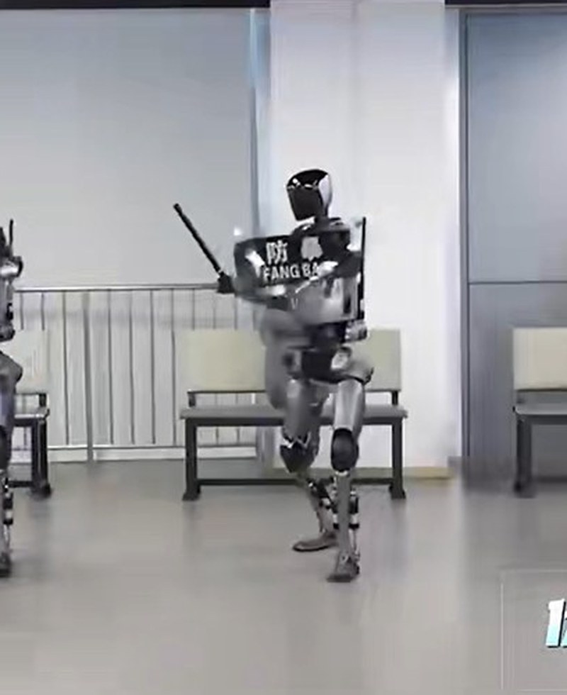 Close crop of one Fuxi humanoid holding a riot shield labeled FANG BAO