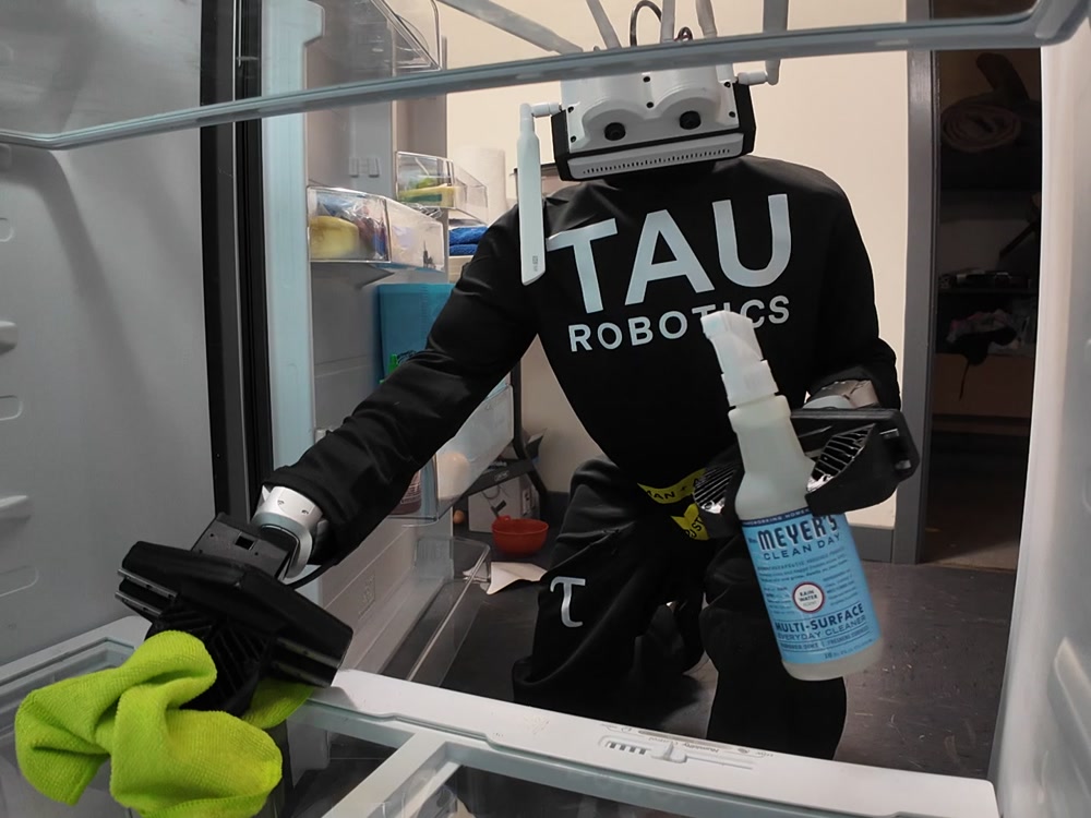 Tau humanoid working near a fridge during a home clean