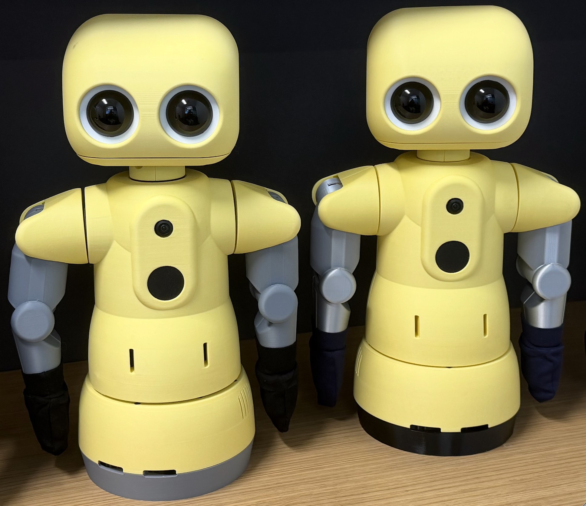 Two yellow 3D-printed THRIVE therapist humanoids side by side