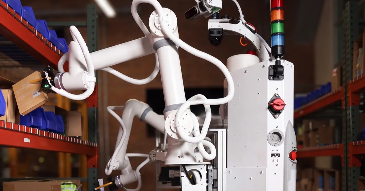 White dual-arm Sonny robot reaching into a warehouse rack of blue bins