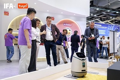 Doova on the Tuya IFA booth floor with visitors watching, AI Robot sign in the background