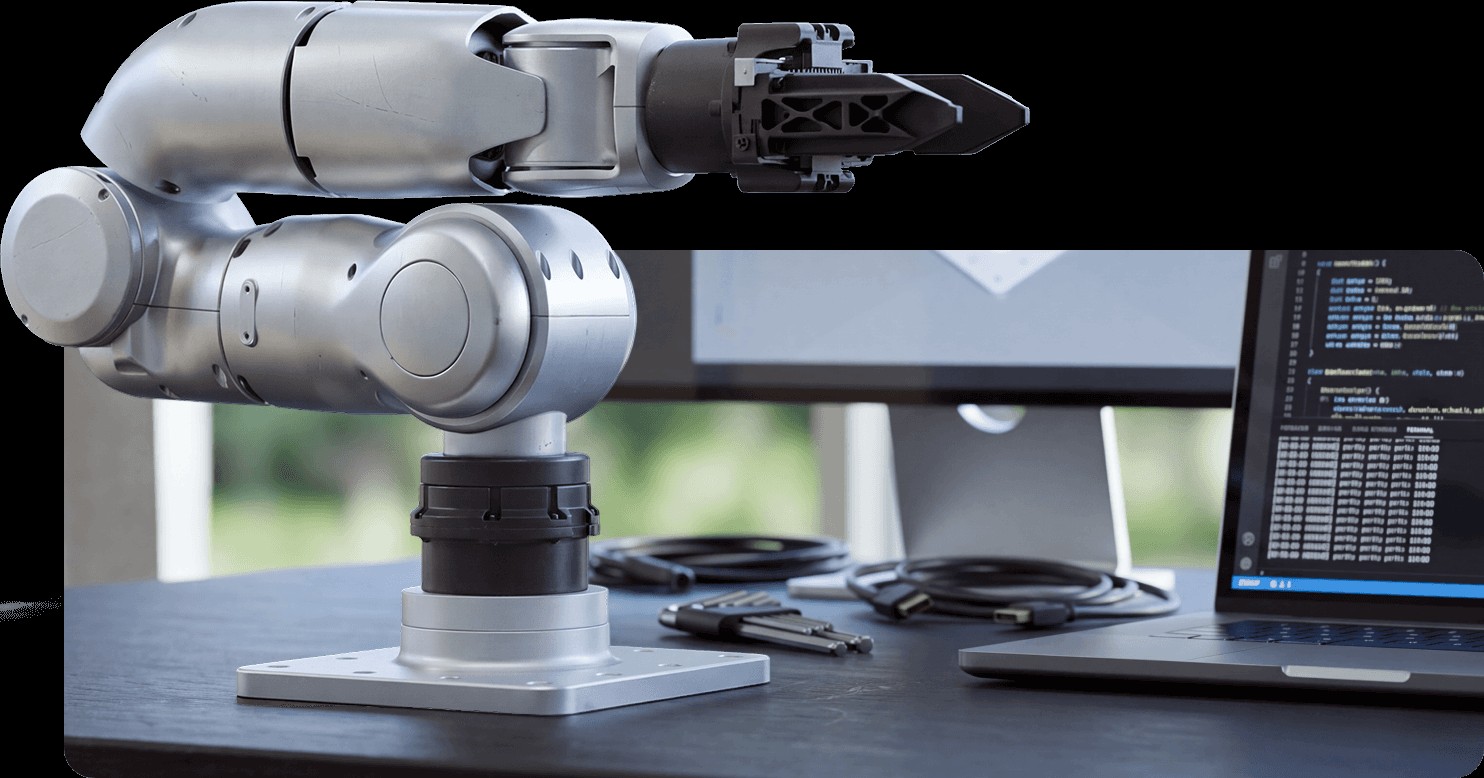 Unitree R1 arm on a desk next to a laptop