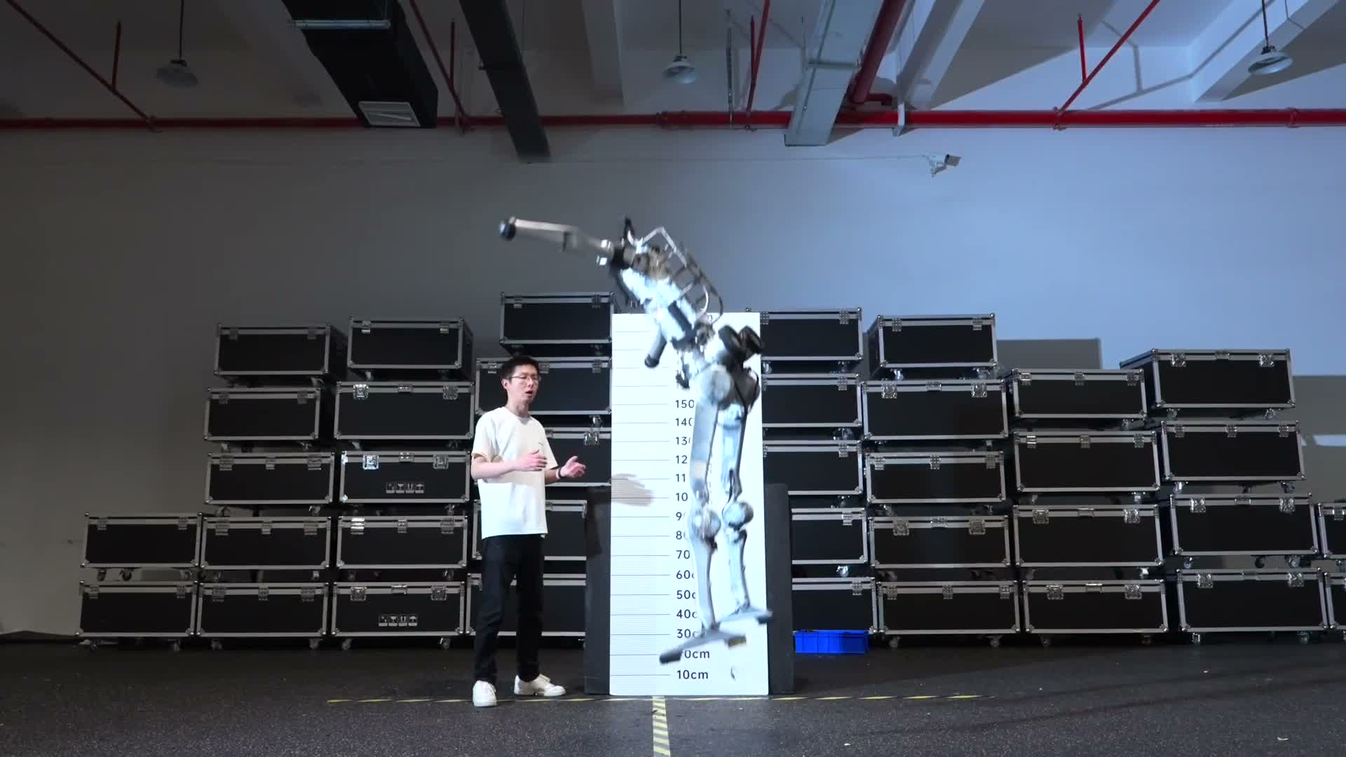 Unitree Superman humanoid in mid-air next to a height board