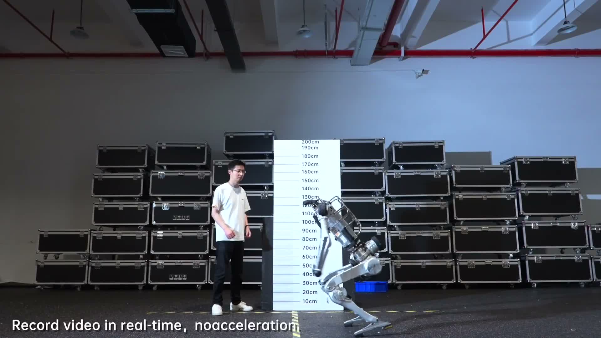 Unitree Superman humanoid crouched beside a 200 cm height board in a warehouse