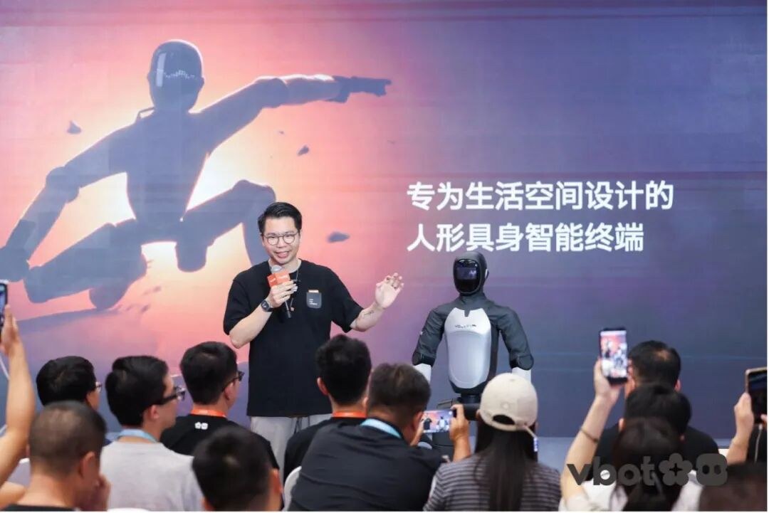 Presenter on stage with ATOM and Chinese text describing a living-space embodied terminal
