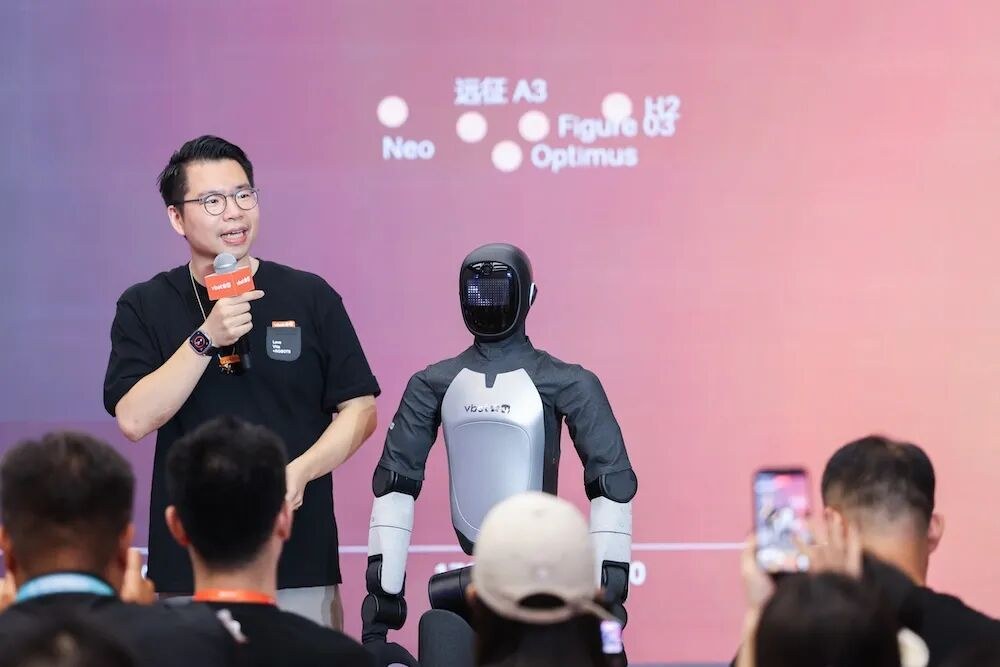 ATOM standing on stage next to a presenter at WRC 2026
