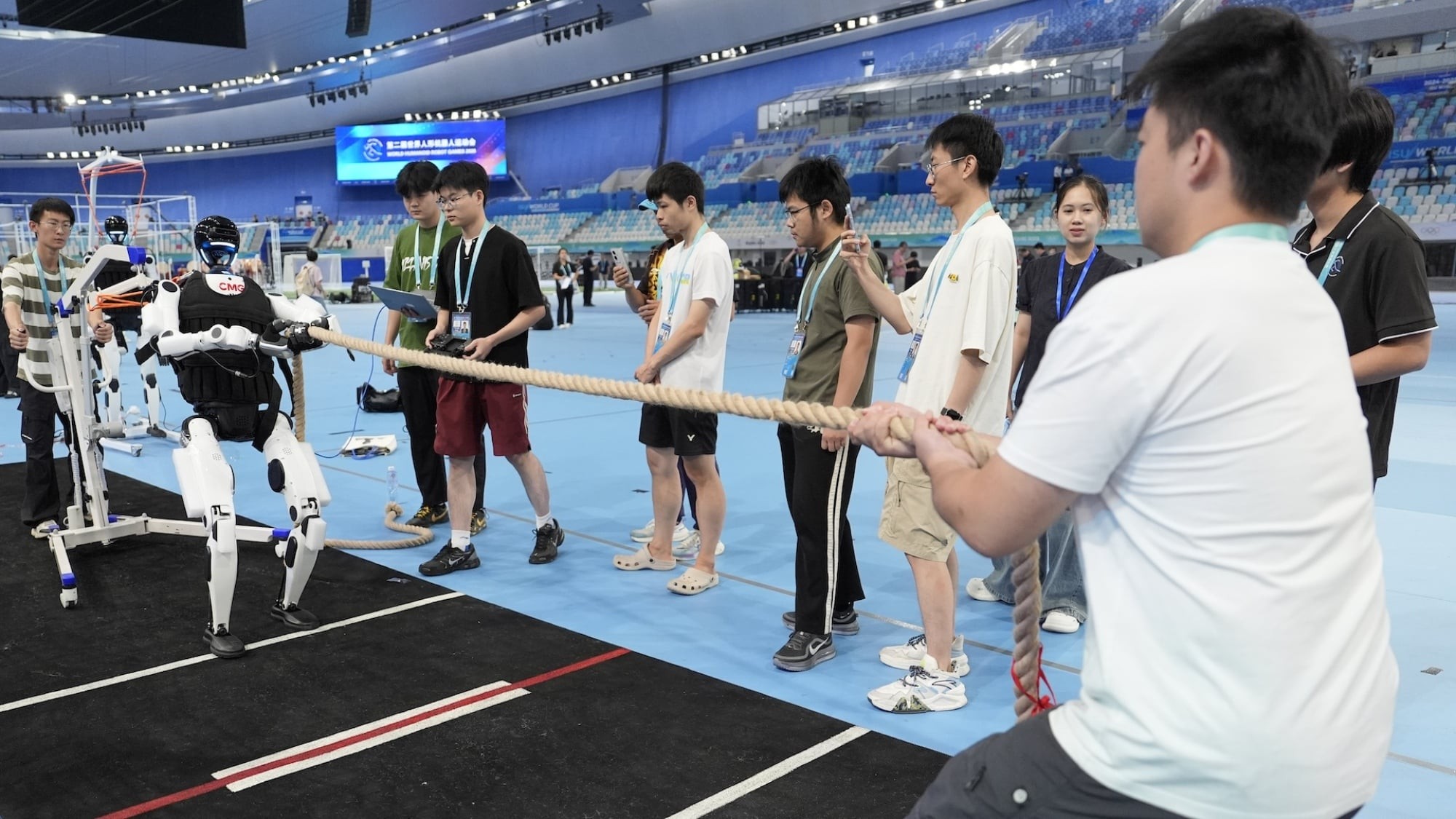 Humanoid pulling a tug-of-war rope against a line of people