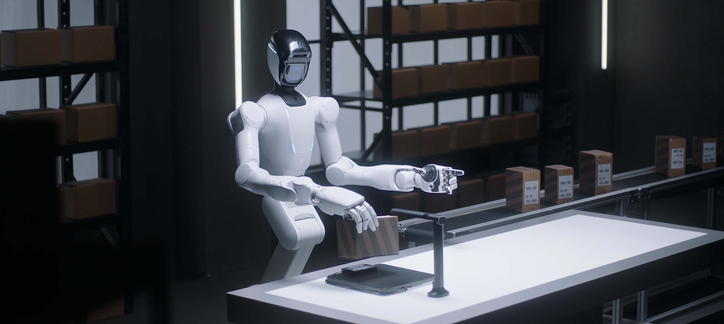 X Square humanoid holding a carton at a warehouse table with boxes on a conveyor