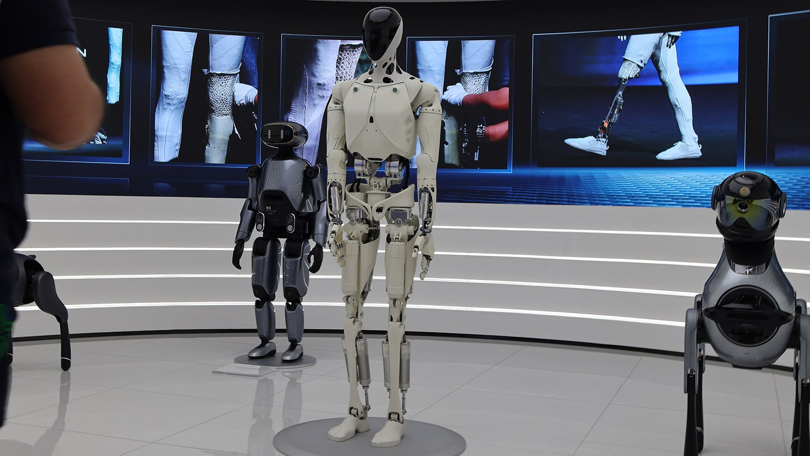 XPeng Iron humanoid standing with companion robots at company HQ display