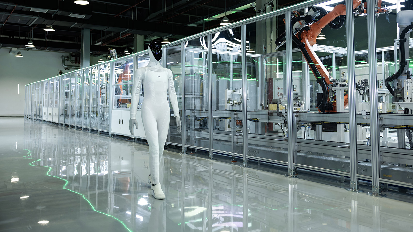 XPeng IRON walking beside glassed-in robot cells on the Guangzhou production line