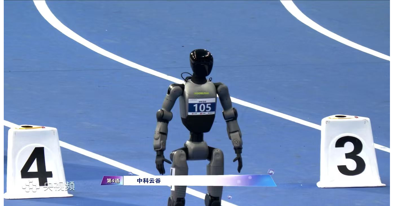 Gray Zoomlion humanoid wearing bib 105 standing on a blue indoor track between lane markers 4 and 3